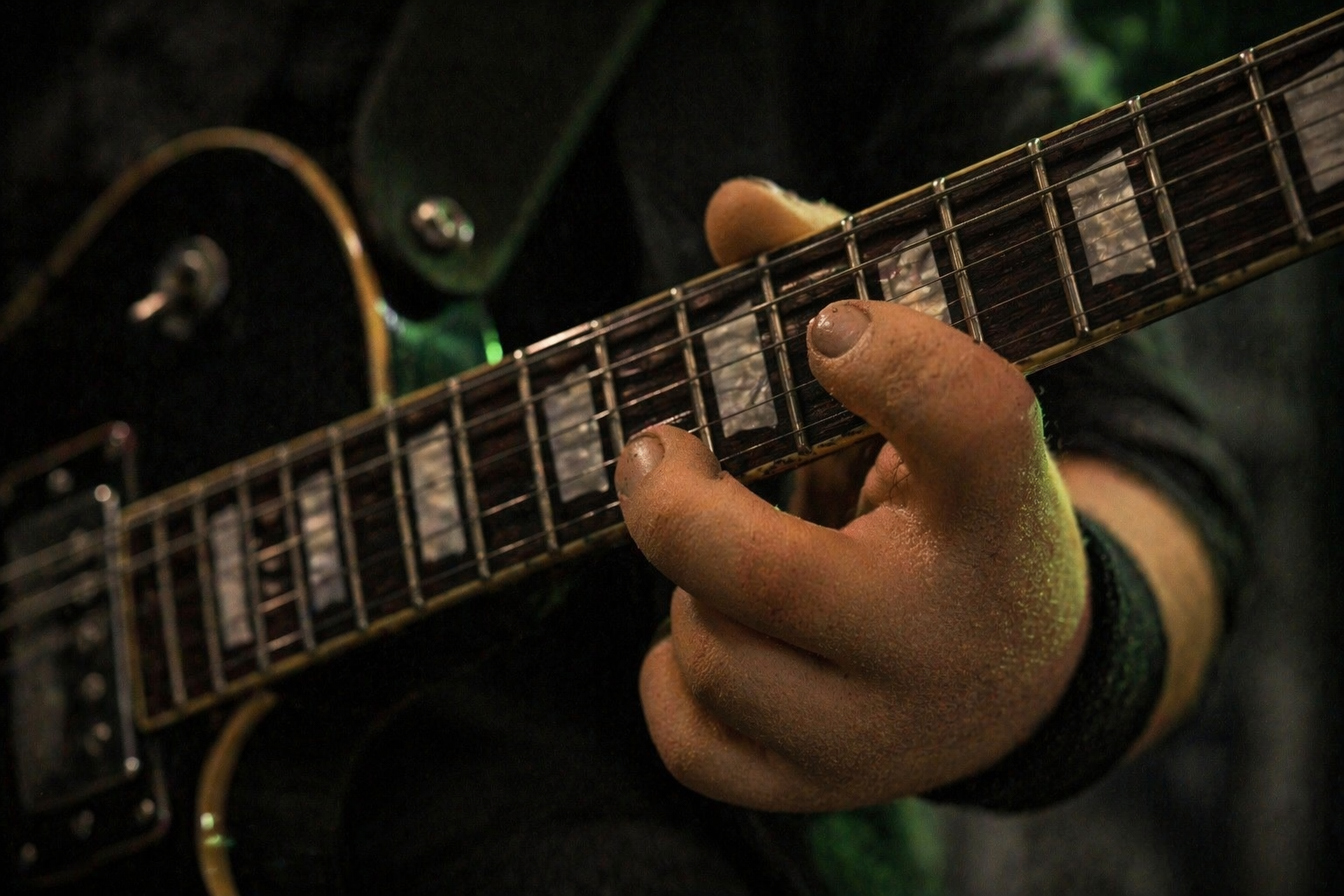 Extreme close-up of a claymation clay hand fretting a black electric guitar, visible fingerprint texture on the strings